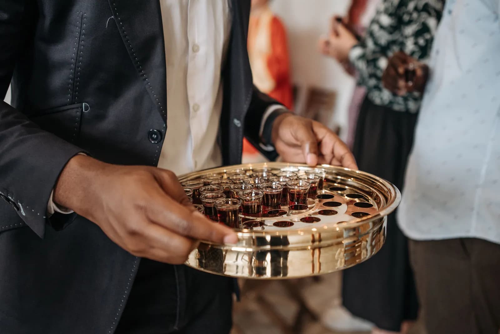 Communion cups being offered on a tray.